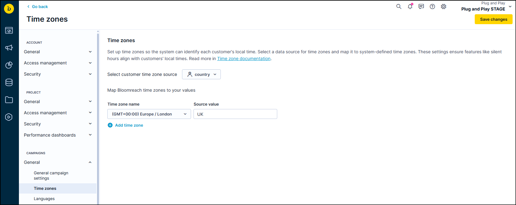 Time zones settings page with "country" selected as customer time zone source and a mapping example showing Europe/London time zone mapped to UK.